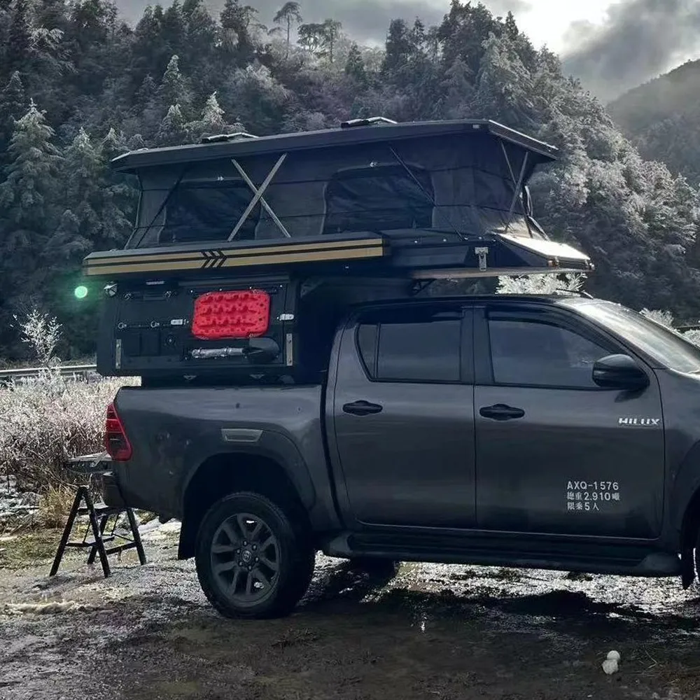 overland truck with rooftop tent in snowy mountains