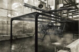 Truck camper chassis frame submerged in an E-coat (electrophoresis) tank for superior rust protection and automotive-grade finish.