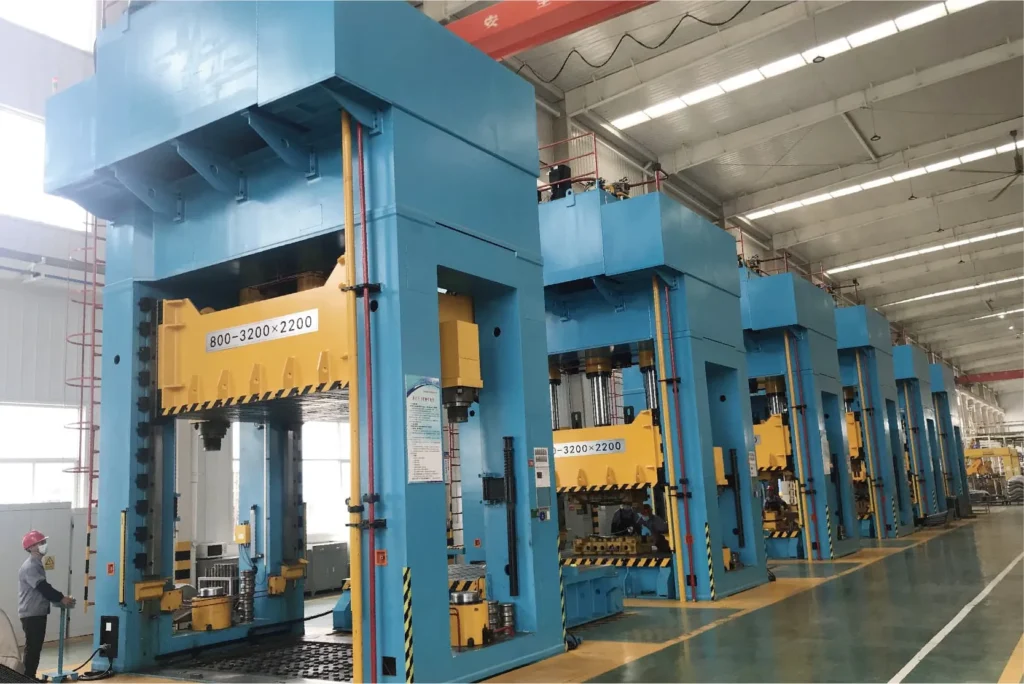 A complete line of heavy-duty blue stamping presses in the factory workshop, manufacturing body panels for truck campers.